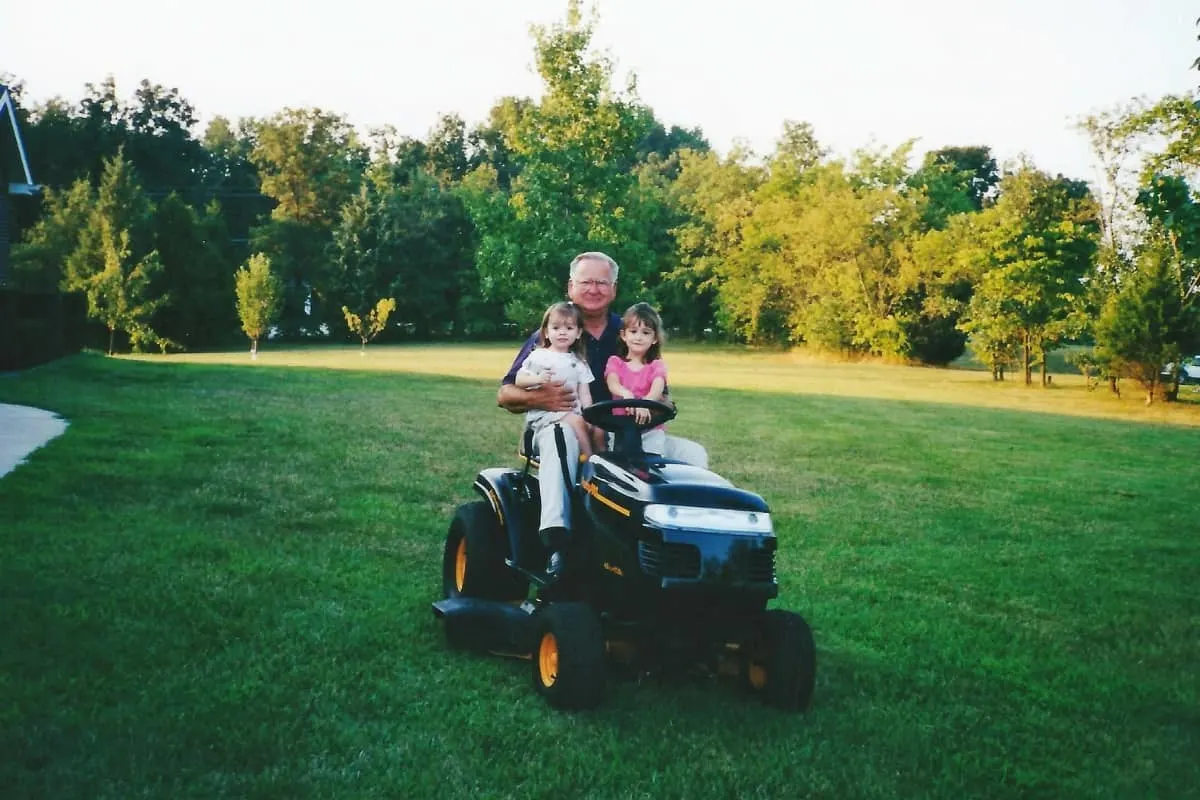 Man with kids on lawn mower